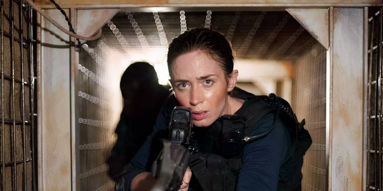 Emily Blunt holding gun in tunnel while searching for drug dealers