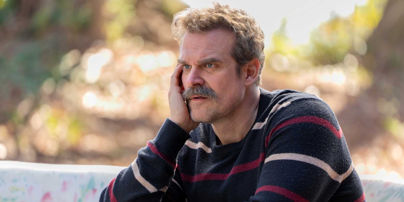 David Harbour as Floyd Smernitch leaning the right side of his face on his right hand in DTF St. Louis