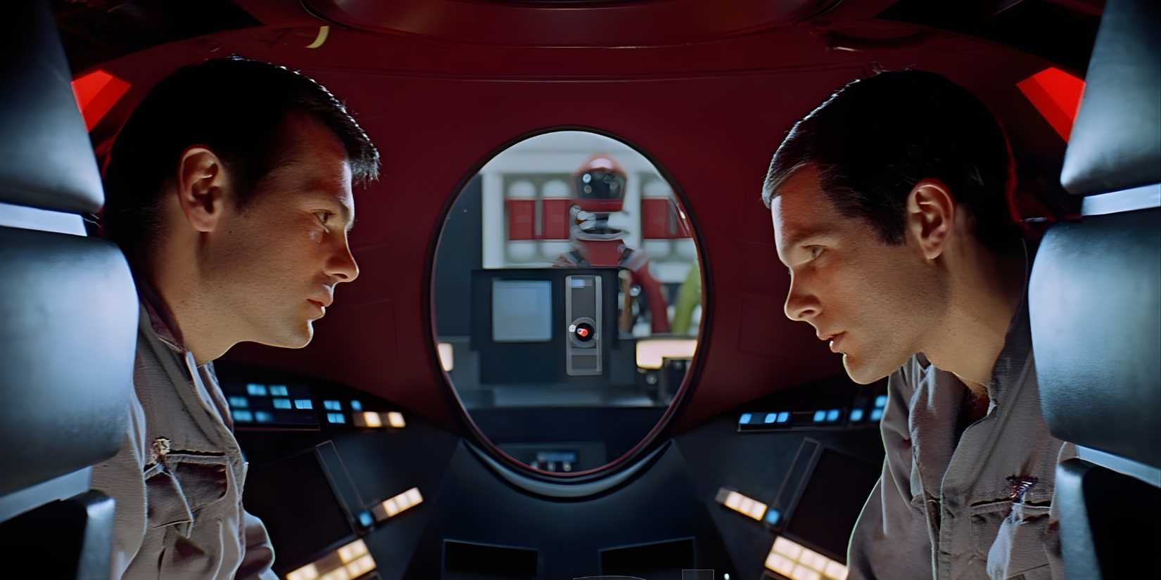 Frank Poole (Gary Lockwood) and Dave Bowman (Keir Dullea) try to have a private conversation as HAL looks on from behind in 2001: A Space Odyssey.