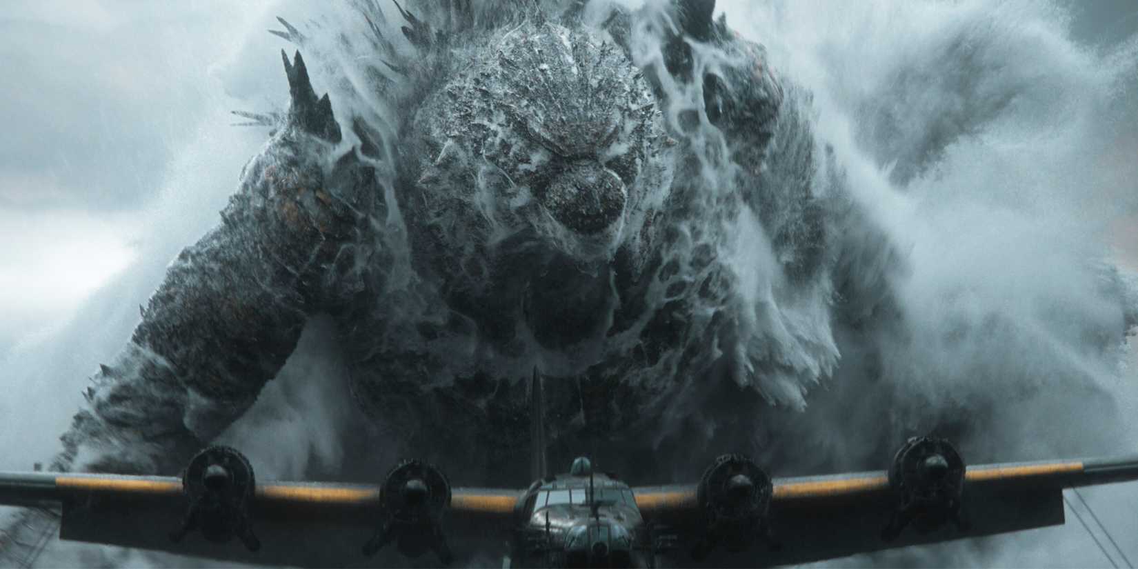 Godzilla emerging from the ocean behind a plane.