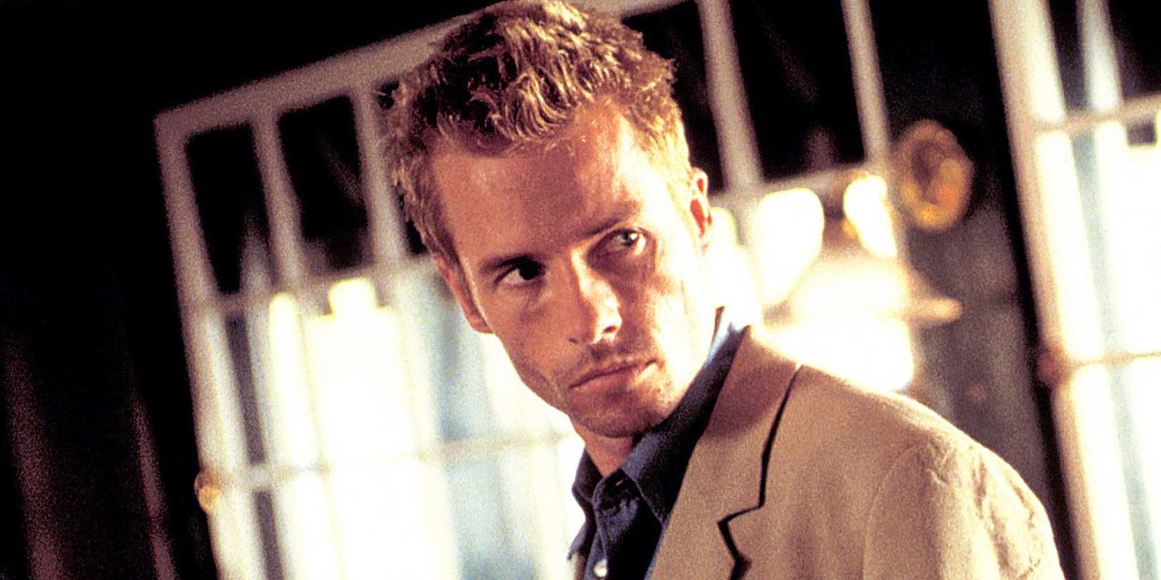 Guy Pearce looks behind him in Memento