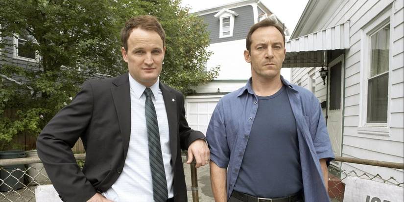 Jason Clarke and Jason Isaacs outside a house looking past the camera in Things Badly Begun episode of Brotherhoood.