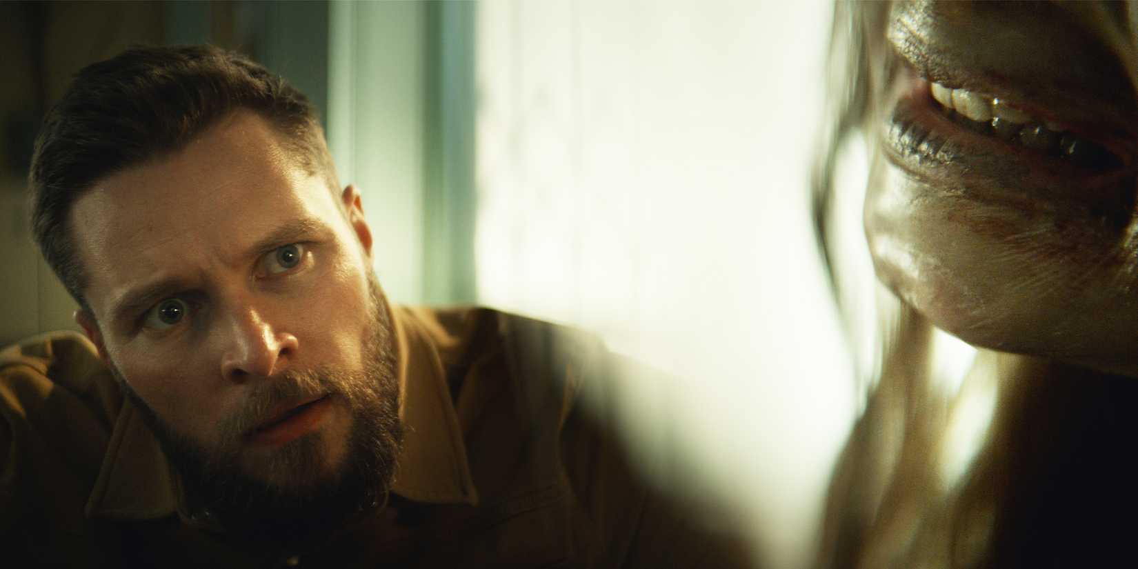 Charlie tilts his head and looks in horror at someone slightly off-screen showing signs of possession. 