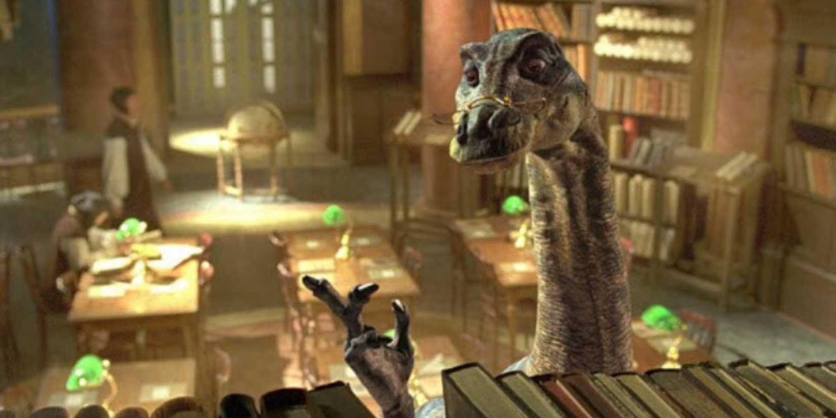 The dinosaur Zipeau, voiced by Lee Evans, wears reading glasses and looks at books on a shelf in Dinotopia