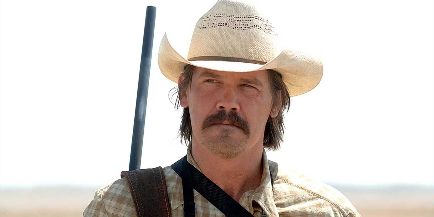 Josh Brolin with a gun on his back in the desert in 'No Country for Old Men'