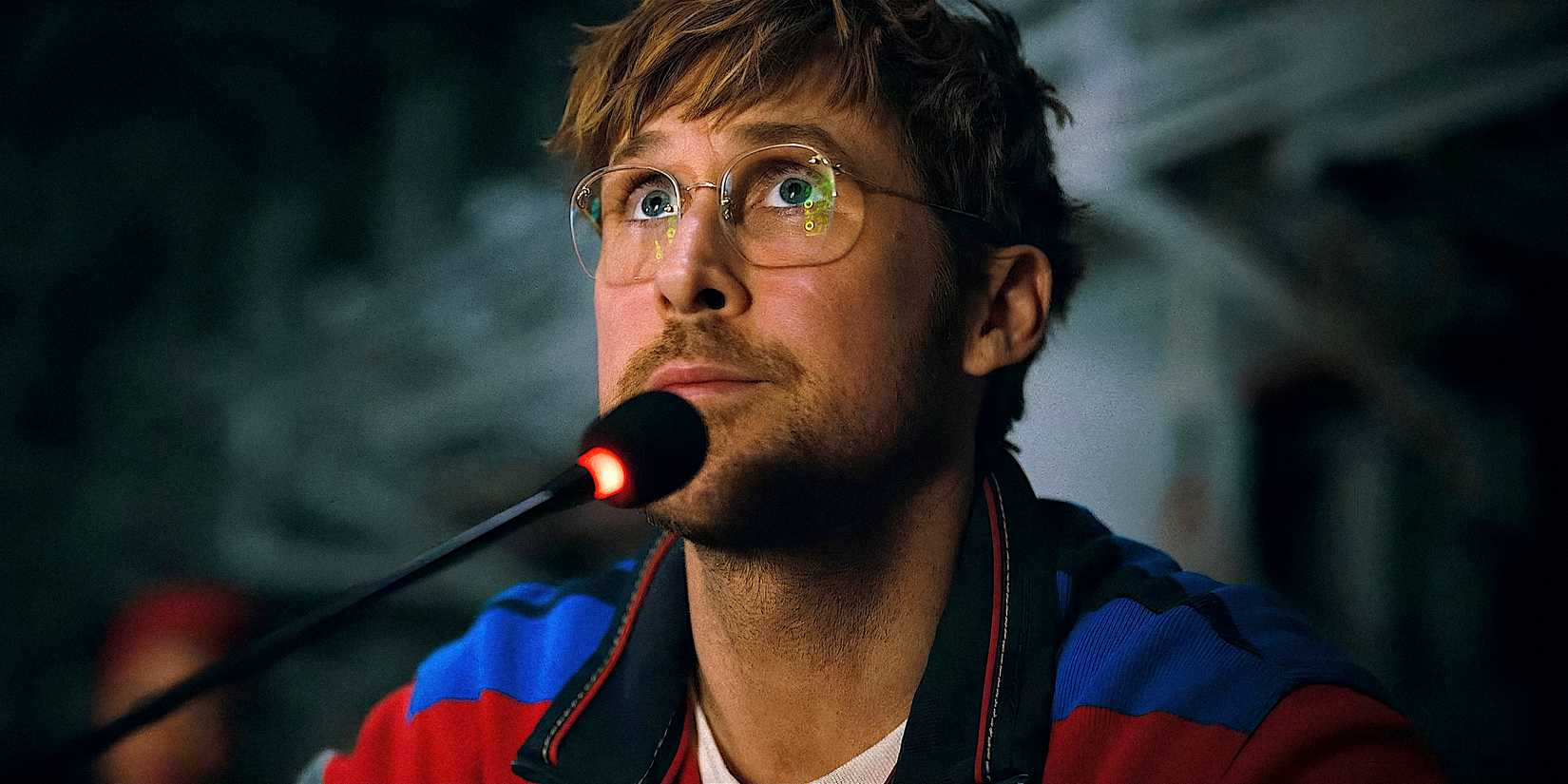 Ryan Gosling sits at a microphone and looks up in Project Hail Mary