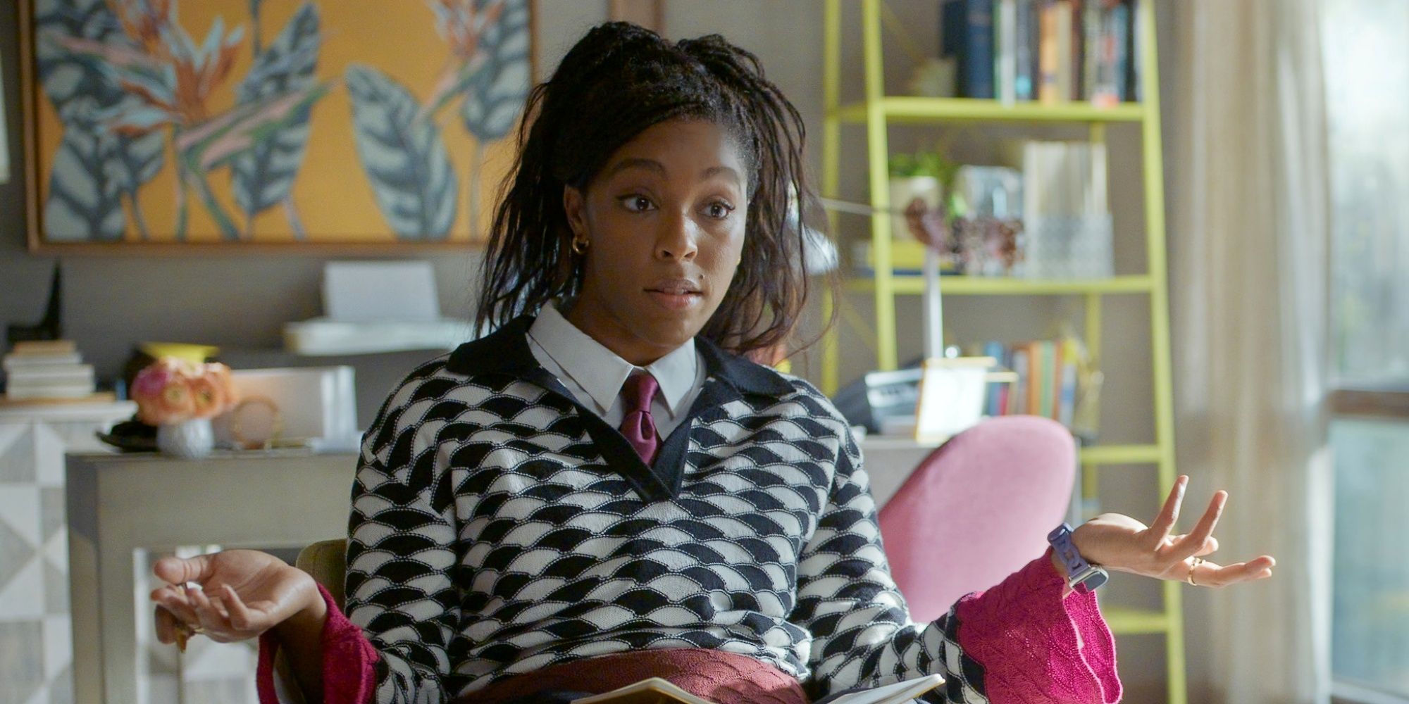Jessica Williams as Gaby sitting in a chair and holding up both her hands in Shrinking Season 3