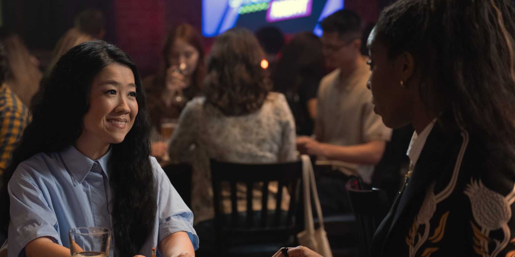 Jessica Williams sitting at a table with Sherry Cola as Maya in Shrinking Season 3