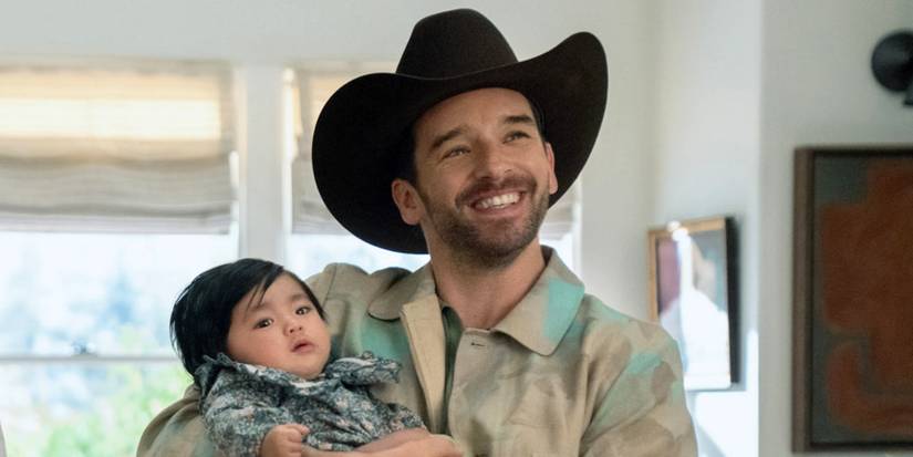 Michael Urie as Brian in a cowboy hat while holding a newborn in Shrinking Season 3