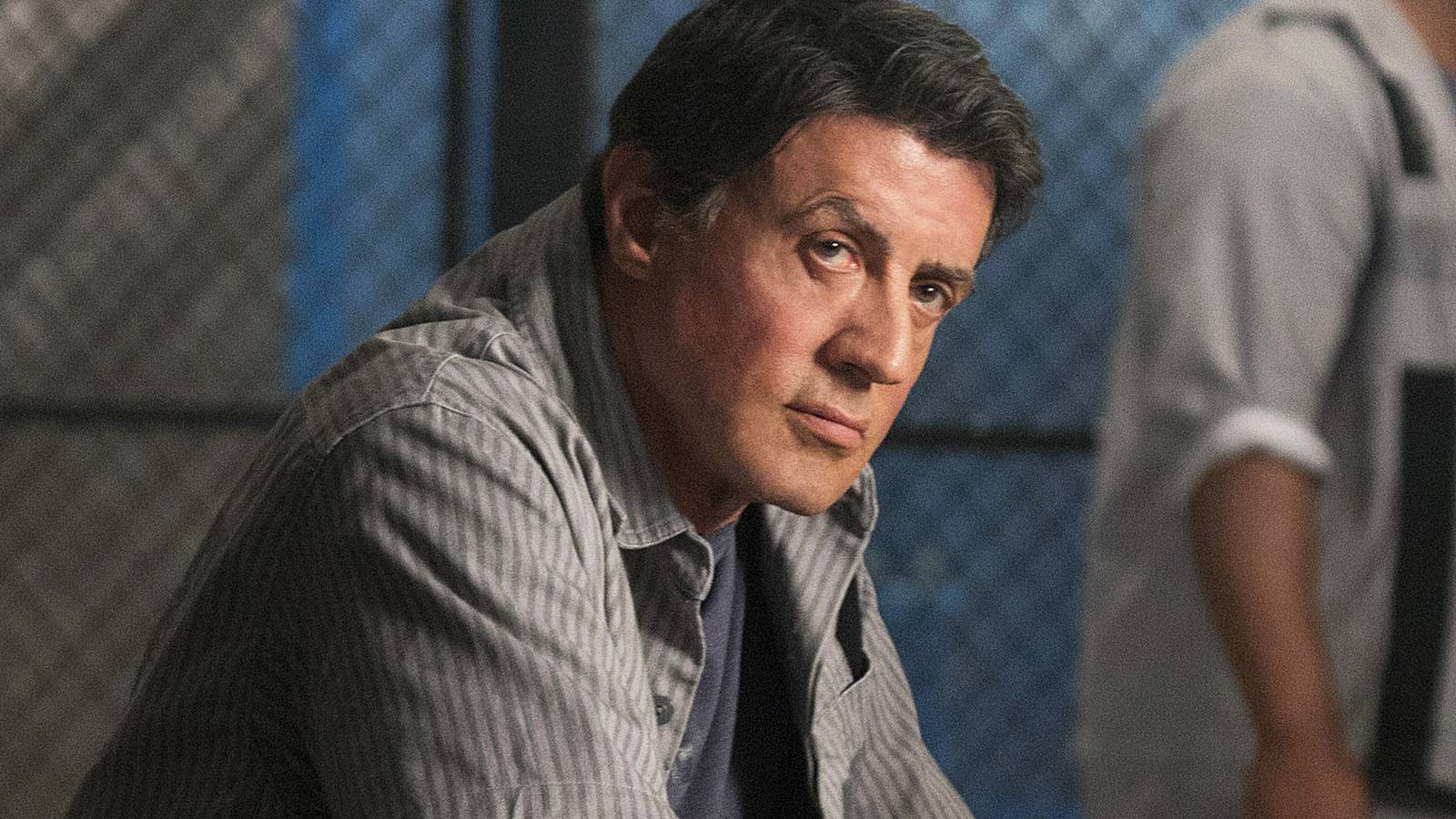 Sylvester Stallone leaning and looking beyond the camera in 'Escape Plan'