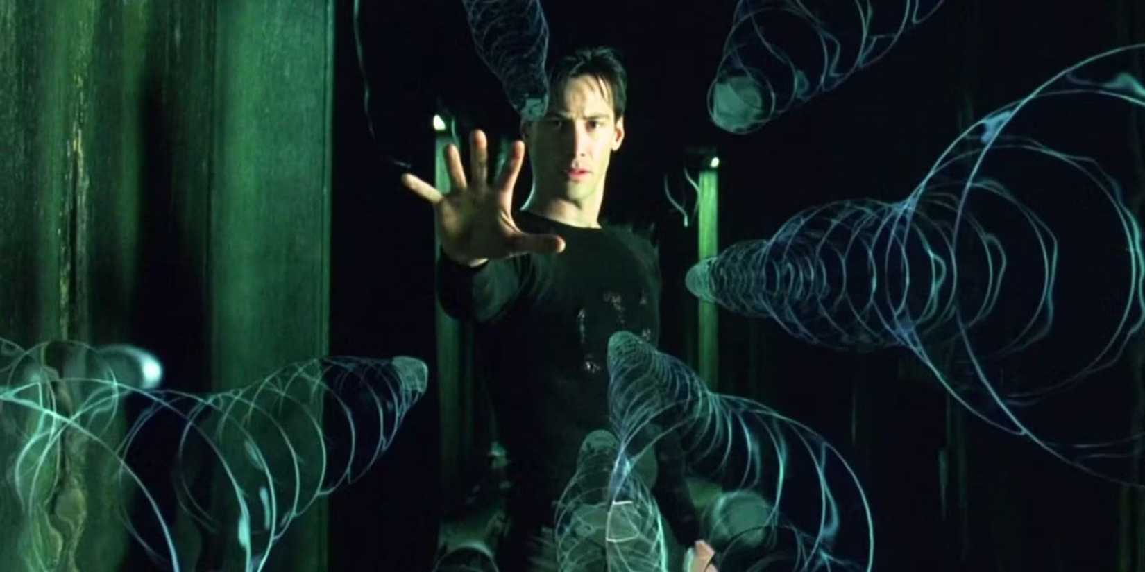 Neo, played by Keanu Reeves, freezes flying bullets with his hand outstretched in The Matrix.