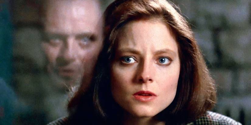 Clarice Starling staring at Hannibal Lecter as his reflection looms in the glass in The Silence of the Lambs