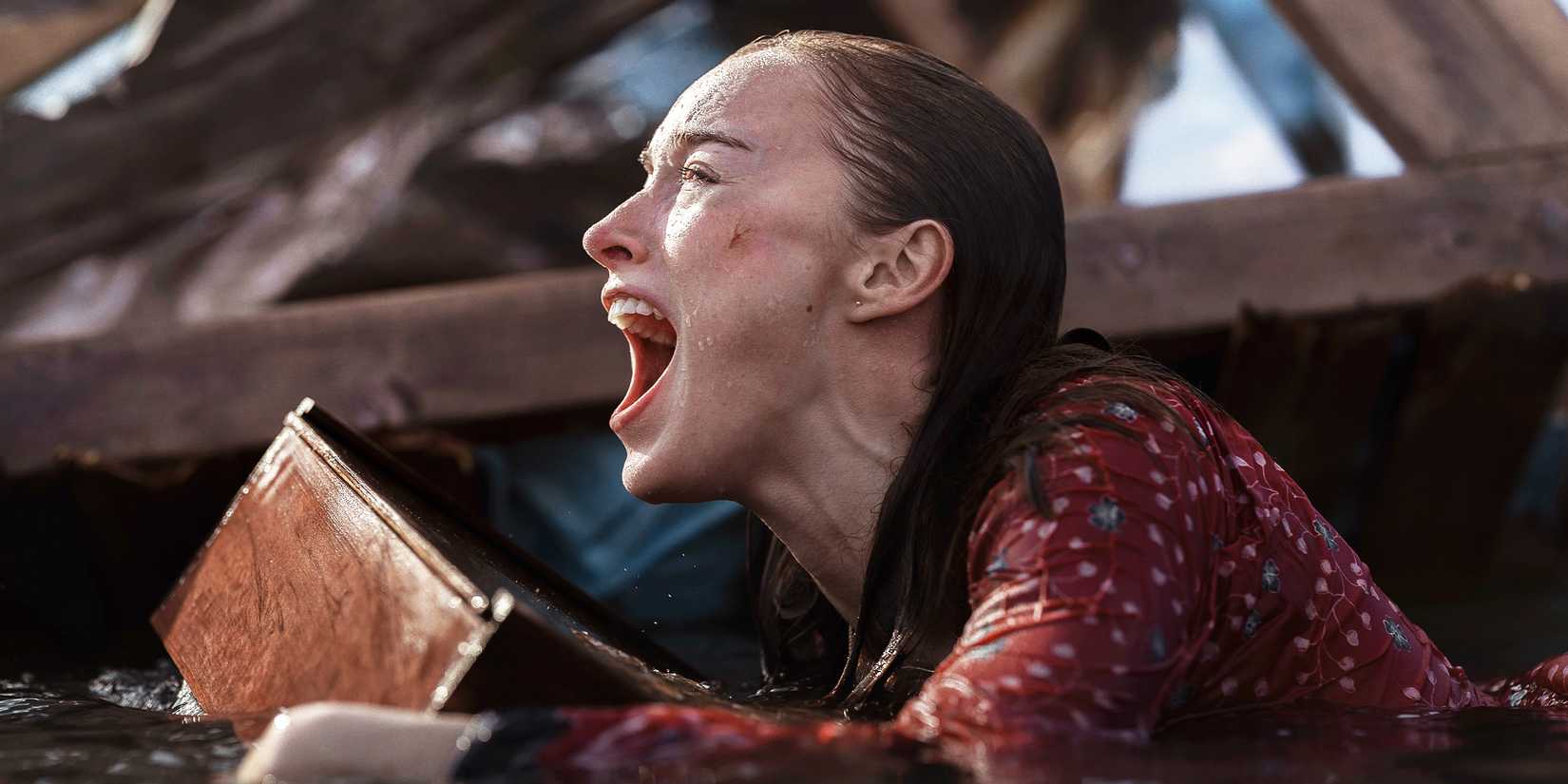 Lisa Fields screams while holding onto debris in flood water.