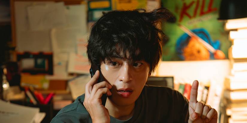 Koo Kyo-hwan talking on the phone and pointing something out in We Are All Trying Here