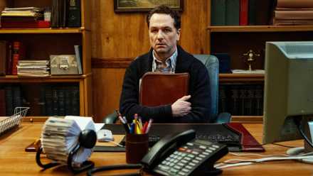 Matthew Rhys clutching a bag and staring ahead at Widow's Bay