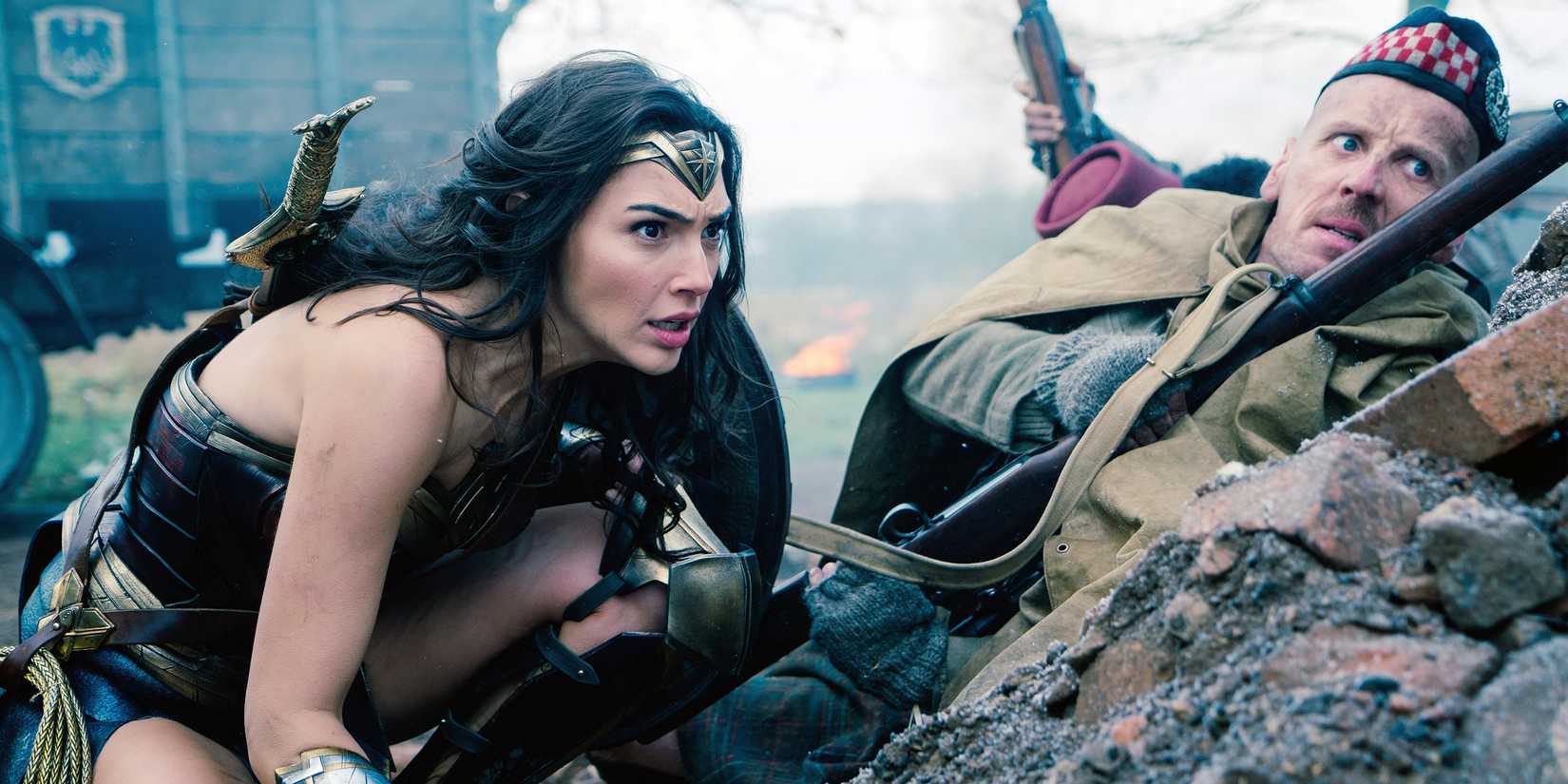 Gal Gadot ready hiding behind a rock in Wonder Woman