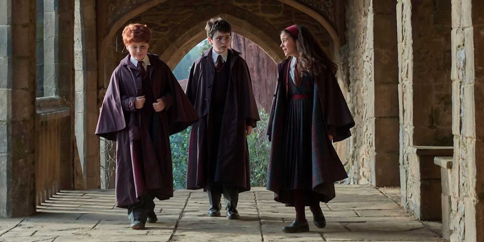 arabella stanton hermione dominic mclaughlin harry alastair stout ron walk down hallway hogwarts in robes harry potter hbo