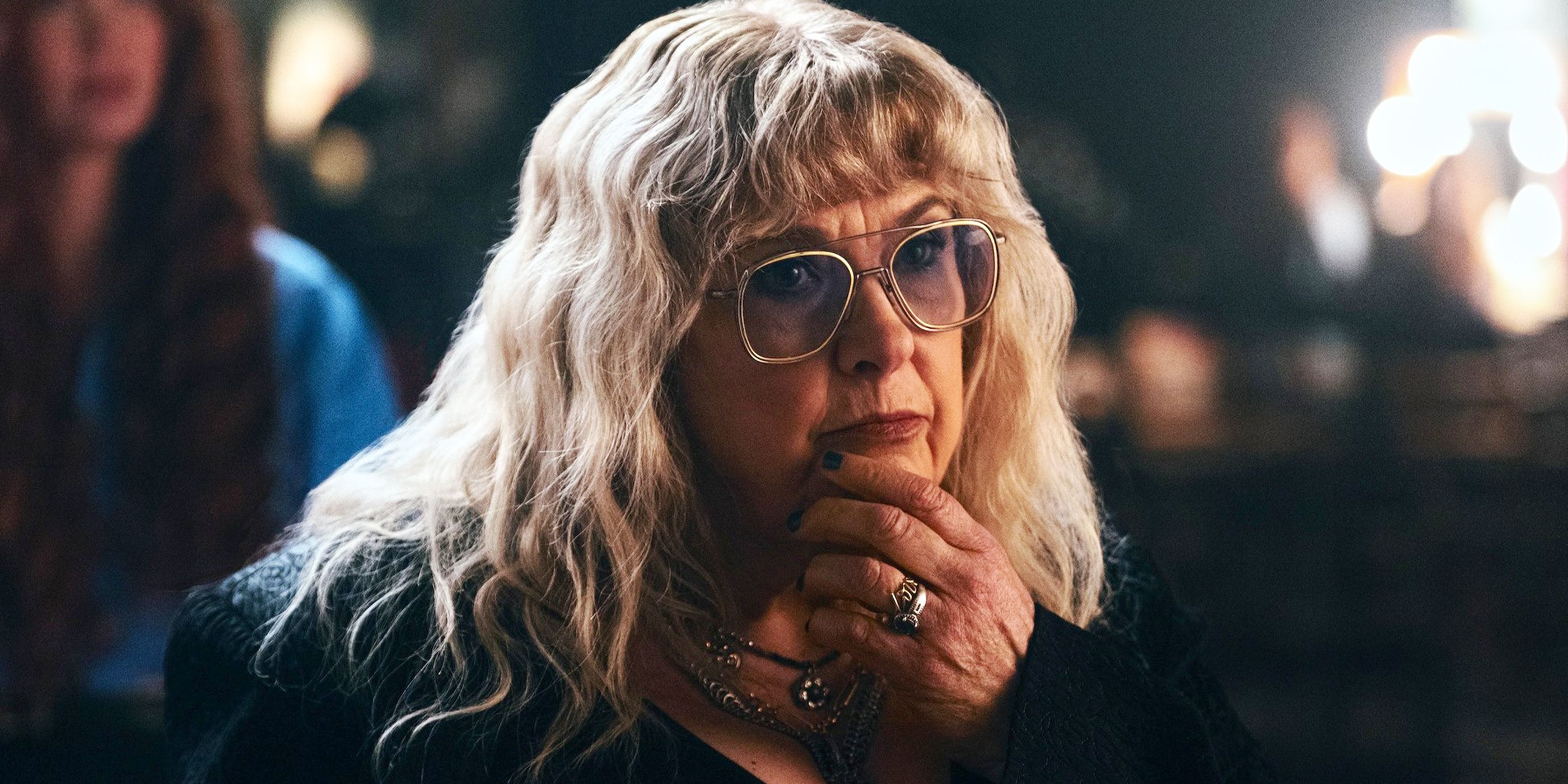 Colleen Camp with her hand on her chin wearing tinted shades in 'Euphoria'
