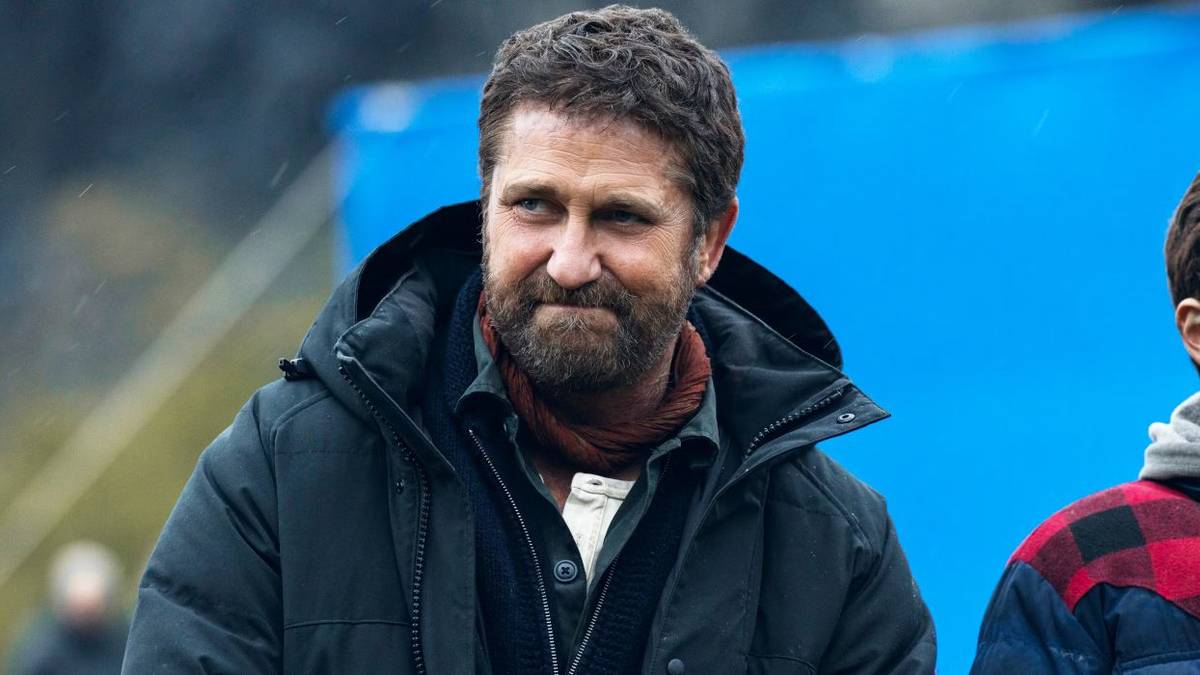 Gerard Butler smiles while wearing a winter coat in Greenland 2: Migration