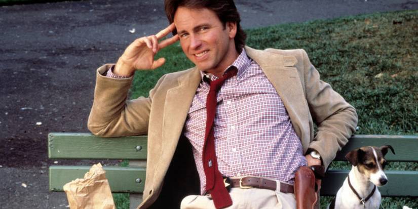John Ritter sitting on a bench with a Jack Russell terrier and smiling in Hooperman