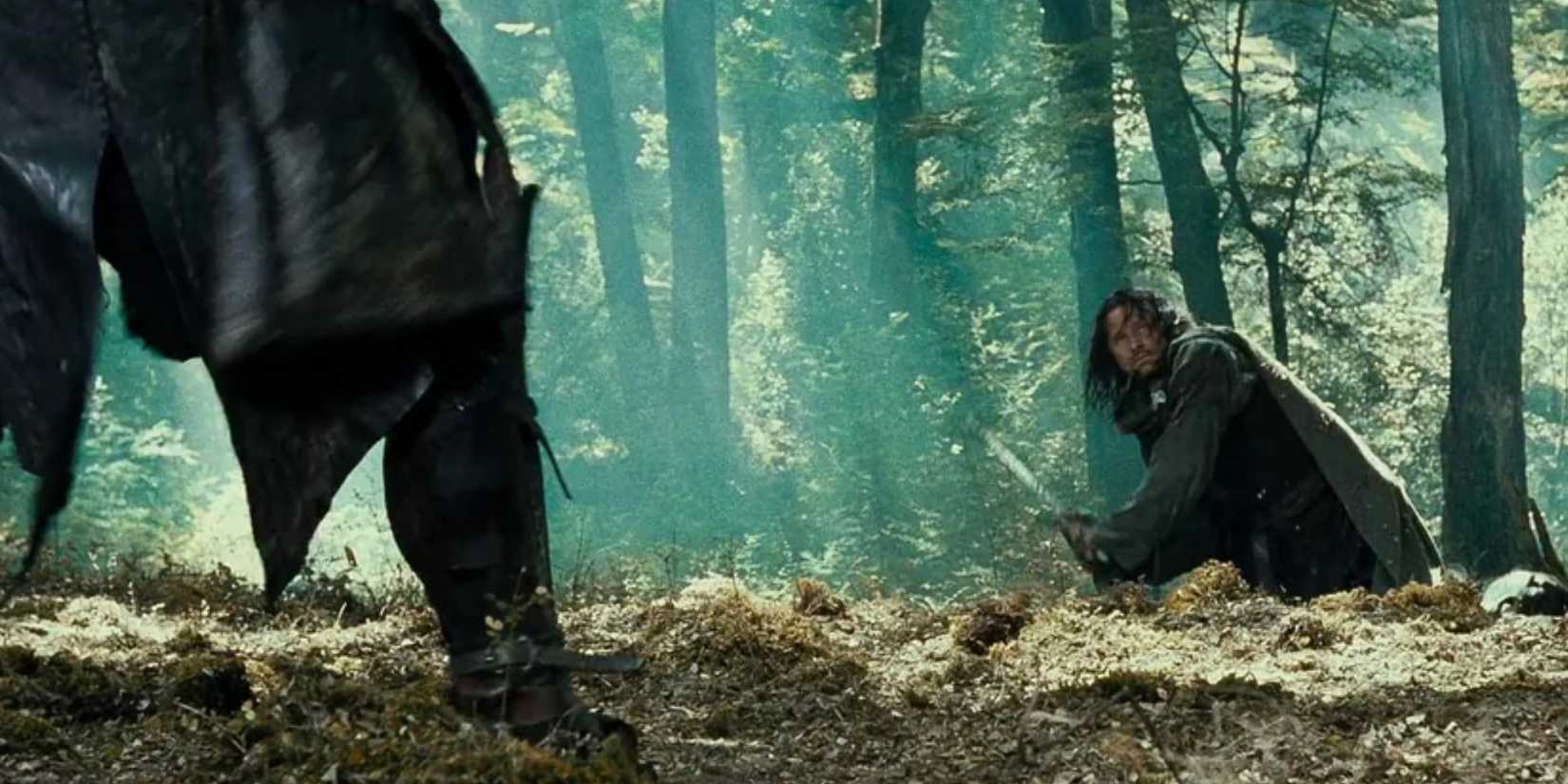 Viggo Mortensen deflects a knife in a forest in The Lord of the Rings