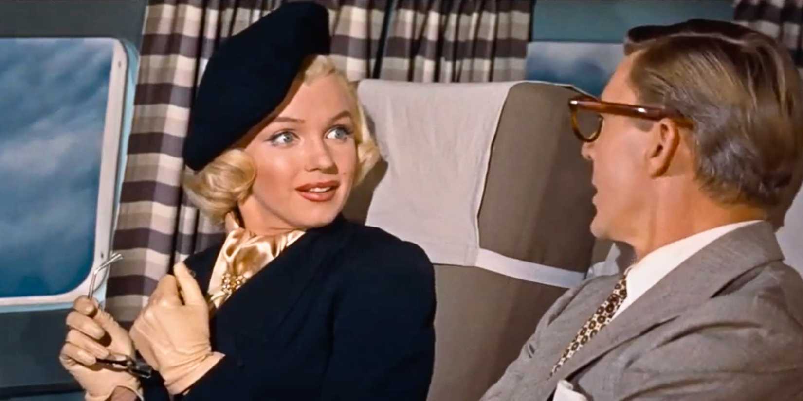 Marilyn Monroe looking at David Wayne sitting next to her on an airplane in How to Marry a Millionaire (1953)