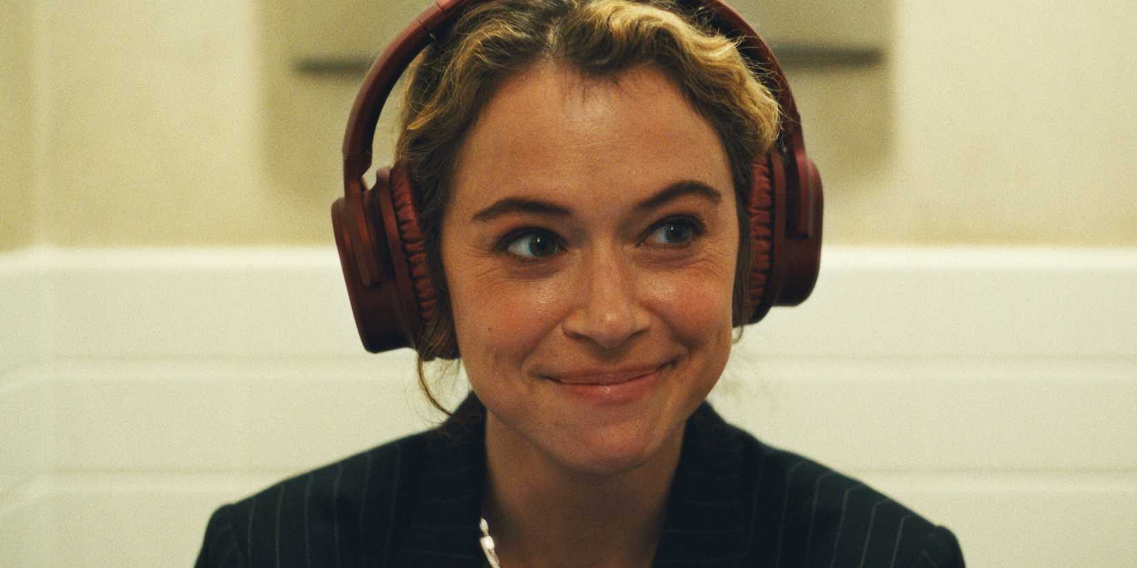 Tatiana Maslany smiling with headphones on in Maximum Pleasure Guaranteed 