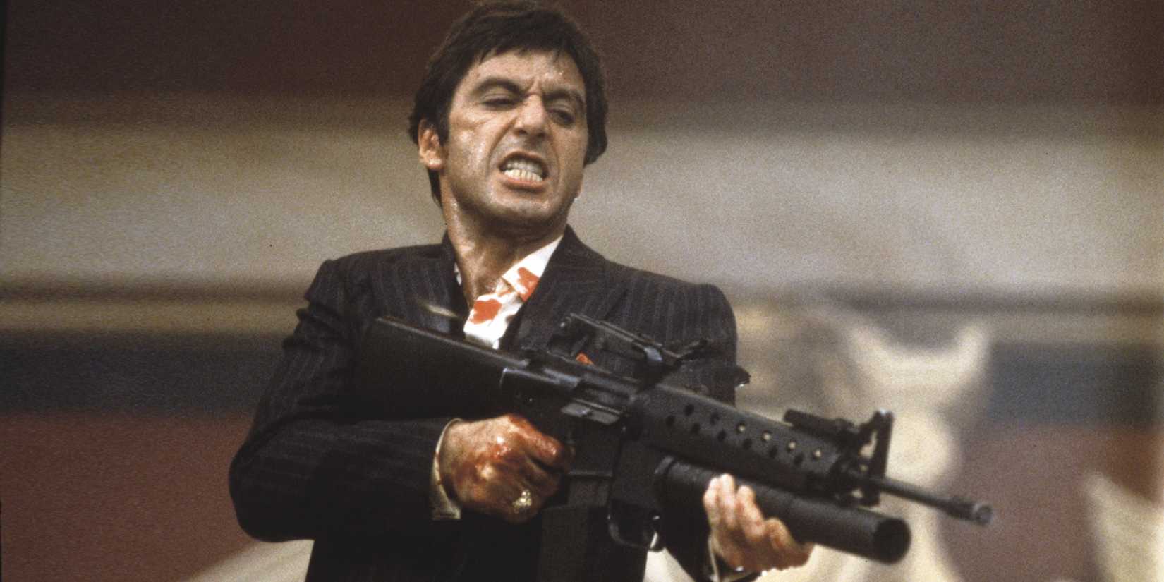 Al Pacino as Tony Montana firing a gun during the ending of Scarface (1983)