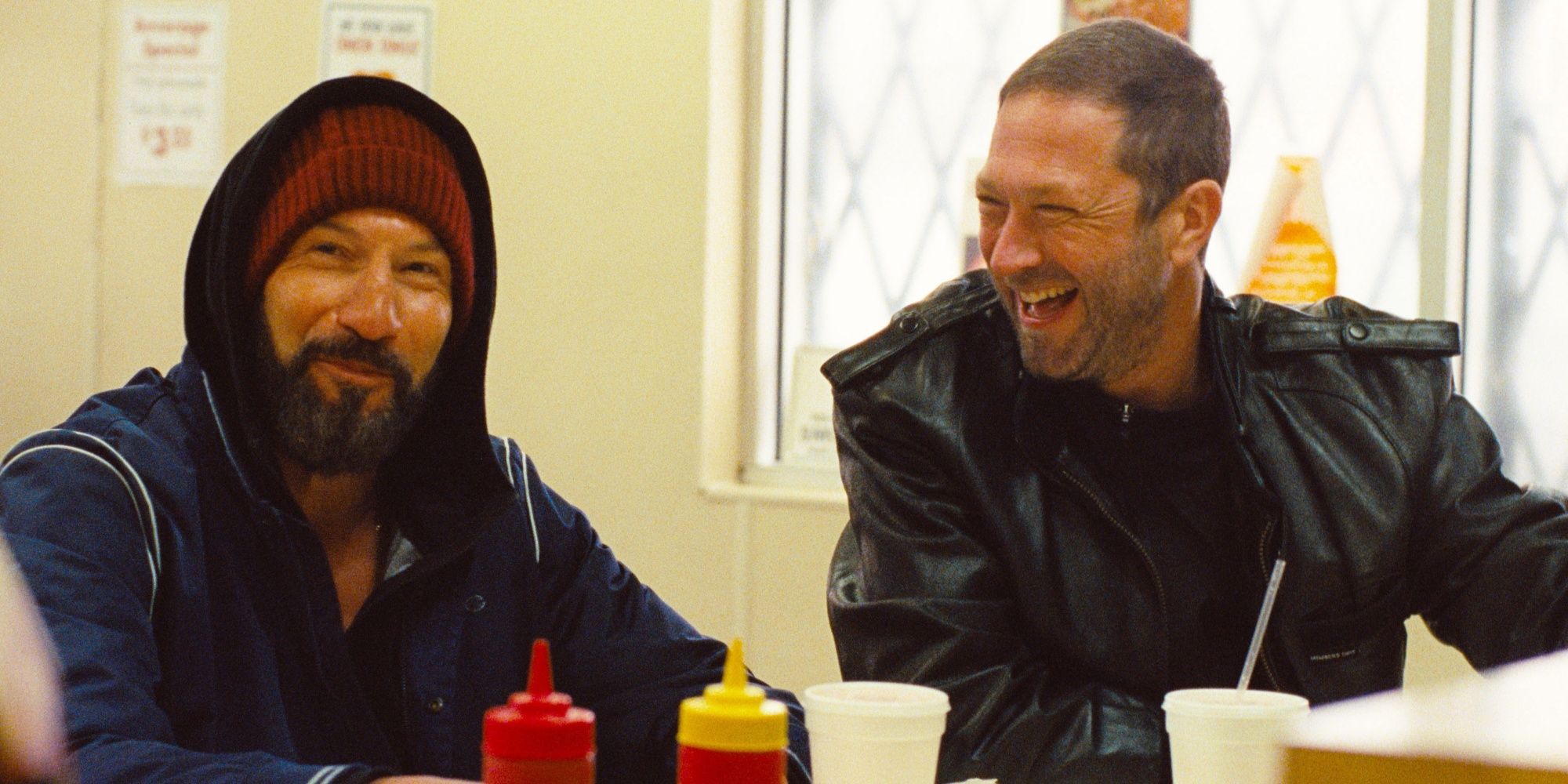 Jon Bernthal as Mikey sitting at a food counter next to Ebon Moss-Bachrach as Richie in 