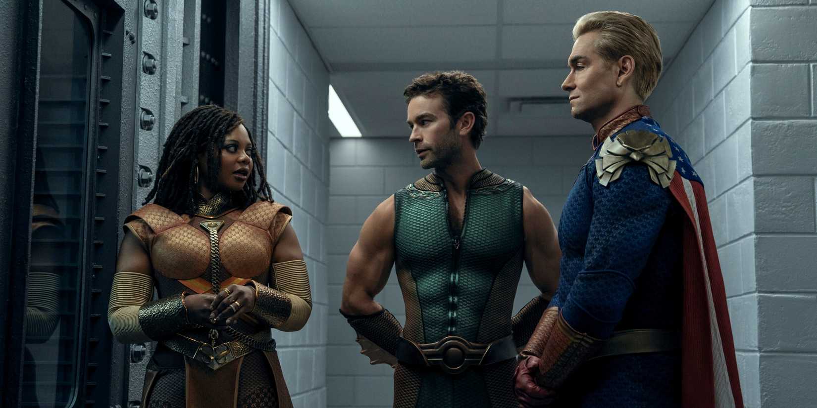 Chace Crawford as The Deep standing between Antony Starr as Homelander and Susan Heyward as Sage in The Boys