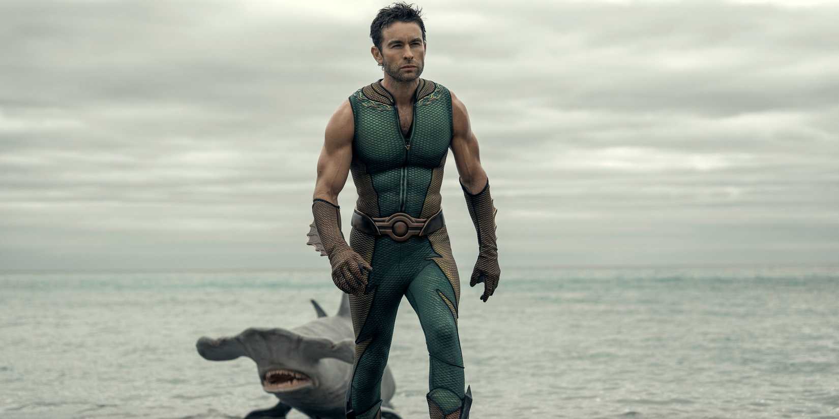 Chace Crawford as The Deep stepping out of the ocean with a hammerhead shark behind him in The Boys Season 5