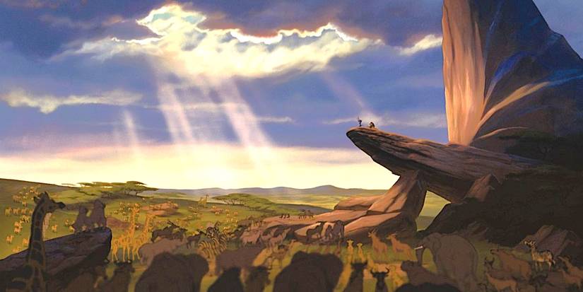 A multitude of animals around Pride Rock as baby Simba is held up by Rafiki and clouds part with sun shining in The Lion King, 1994