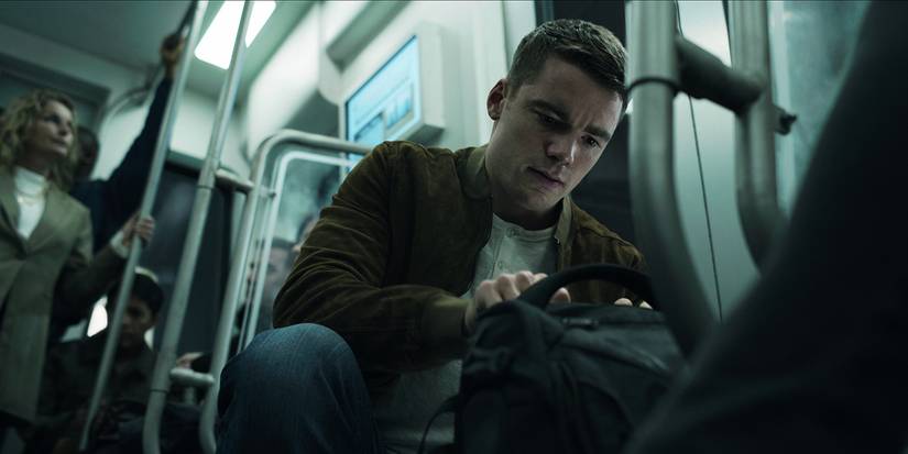Peter crouched down finding a bomb on a train in The Night Agent.