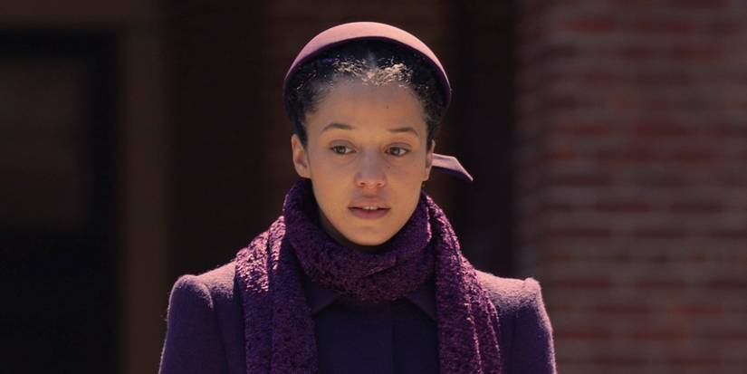 Chase Infiniti as Agnes in her full Plum uniform, hat, coat and scarf in The Testaments