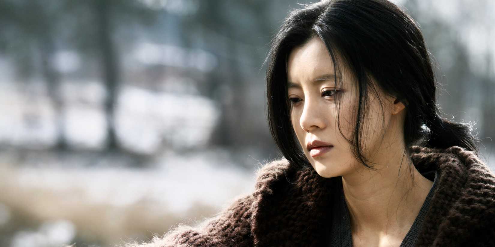 A woman looks melancholic outdoors in The Uninvited, Korean horror movie 
