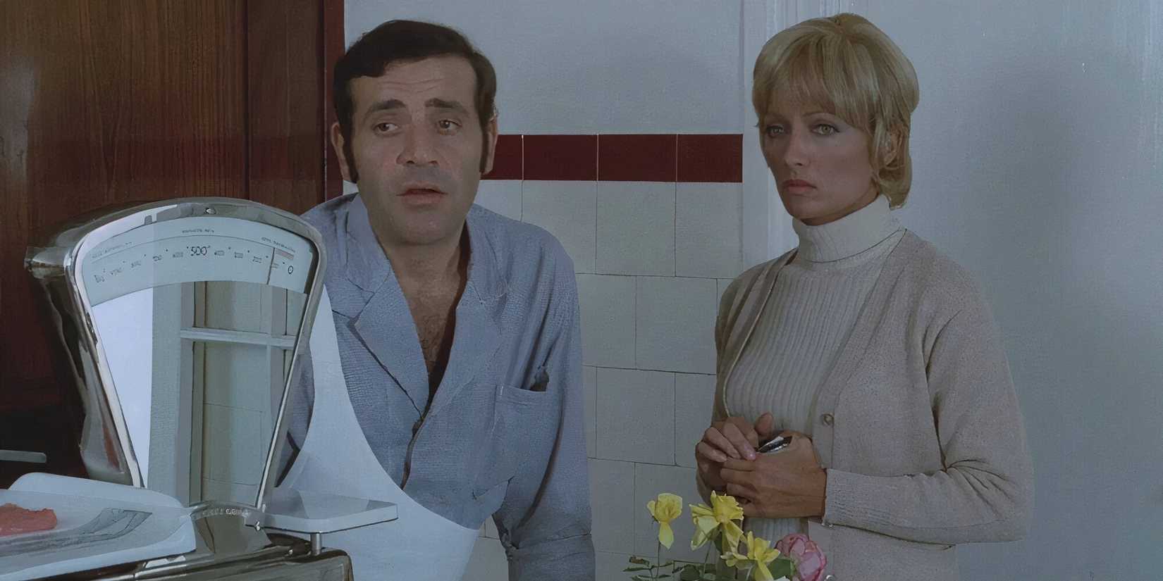 A man and a woman standing next to a scale in 'The Butcher' (1970)
