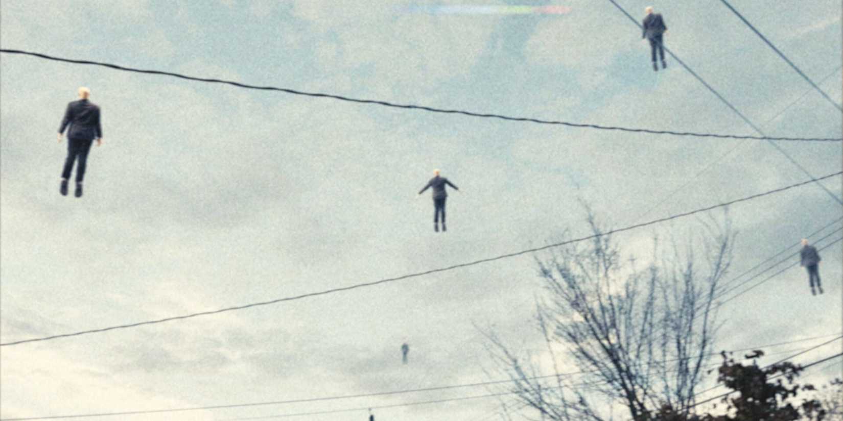 Various men in suits facing away from the camera and far away floating into the sky in 'Buffet Infinity'