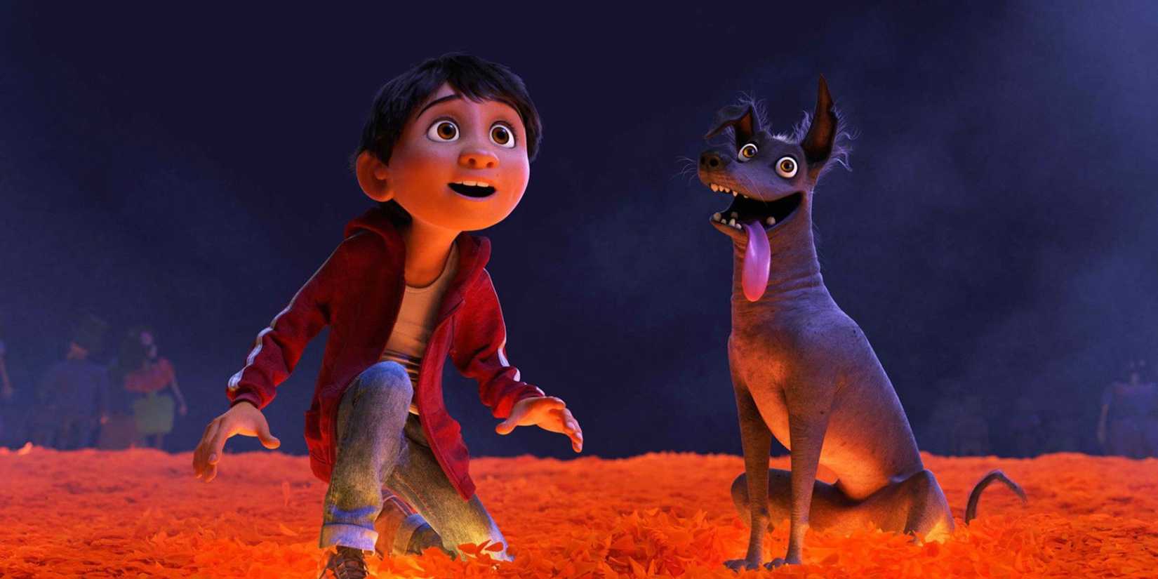 Miguel kneels on a bridge to the Land of the Dead with a dog nearby in Coco
