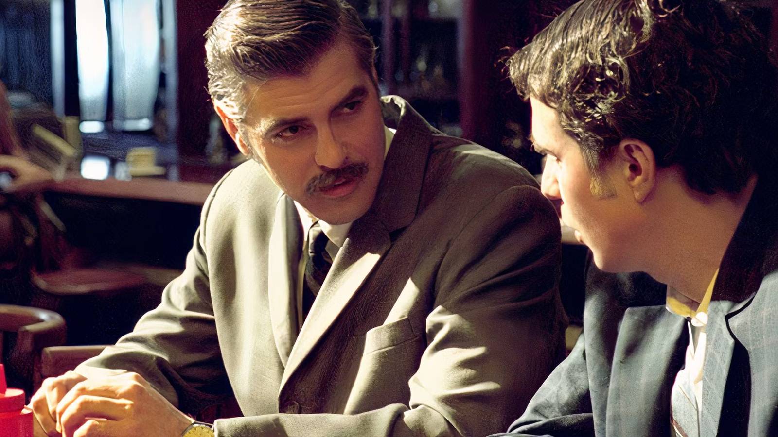 George Clooney talking to a costar at a restaurant in Confessions of a Dangerous Mind.