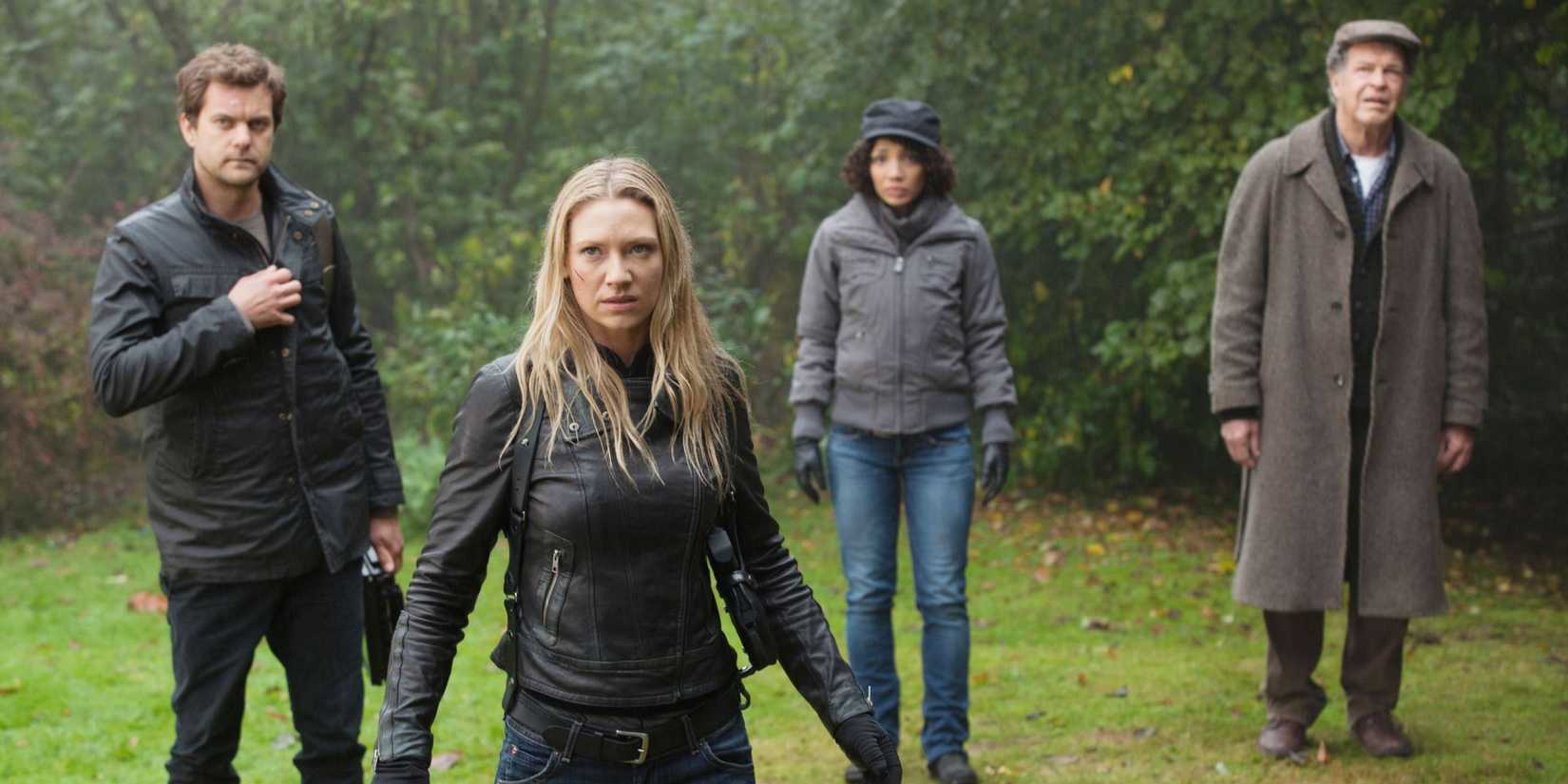Joshua Jackson, Anna Torv, Jasika Nicole, and John Noble standing outdoors looking pensive in the "Black Blotter" episode of Fringe
