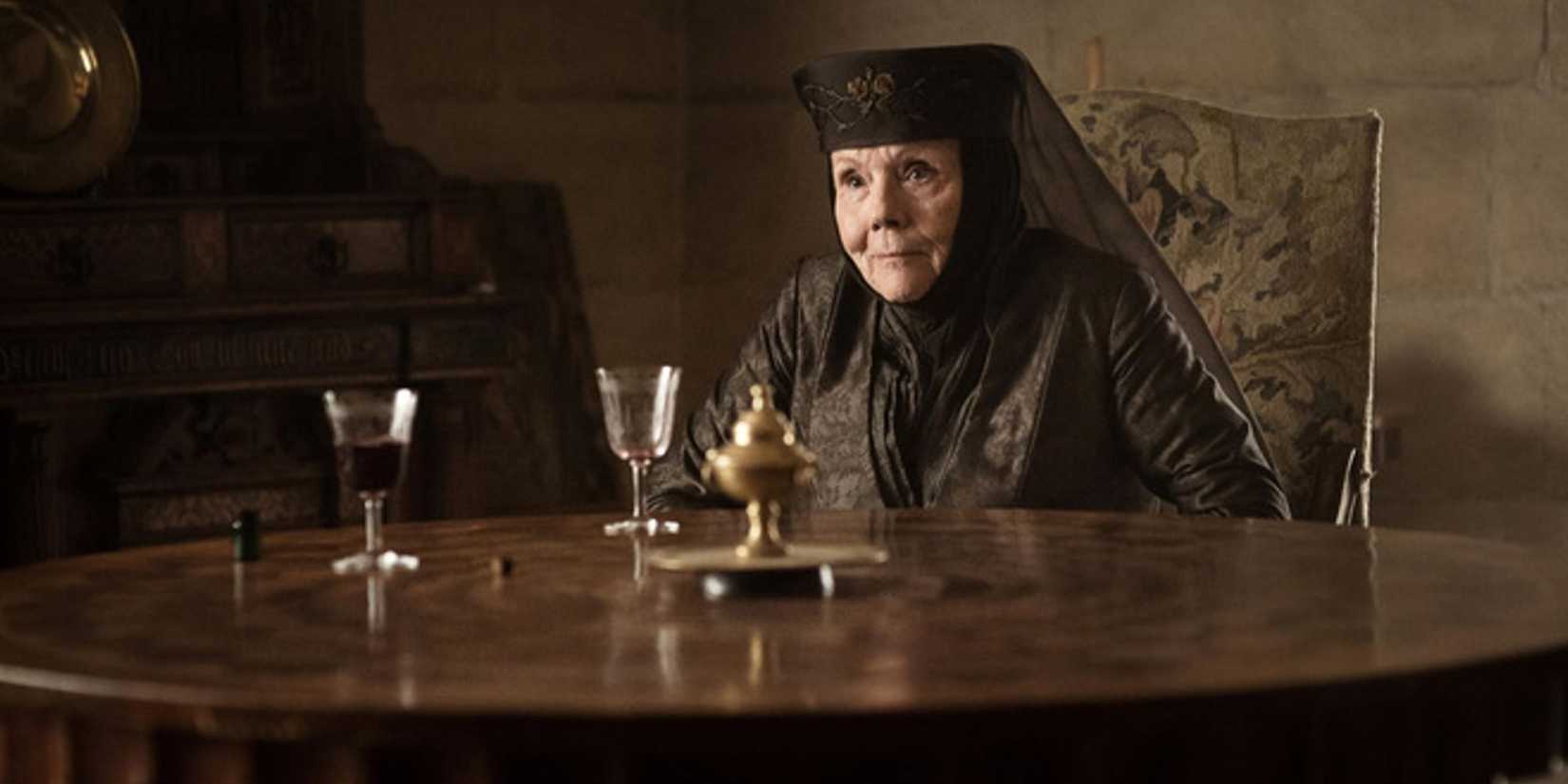 Olenna Tyrell (Diana Rigg) sitting at a table in 'Game of Thrones'