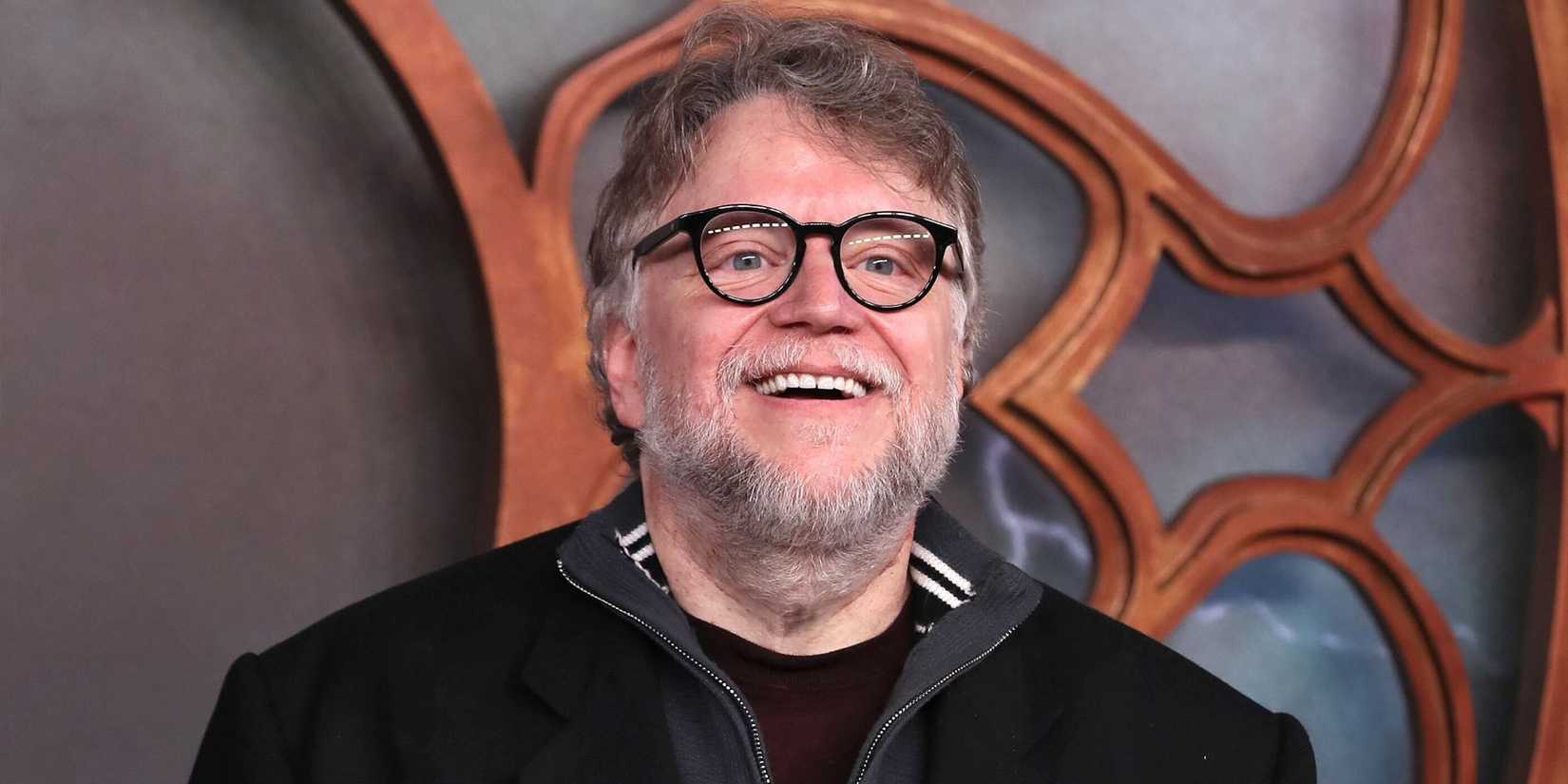 Guillermo del Toro smiling while looking at something