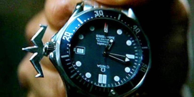 A close-up of a blue Omega Seamaster wristwatch with a grapplig hook on its left side in The World Is Not Enough
