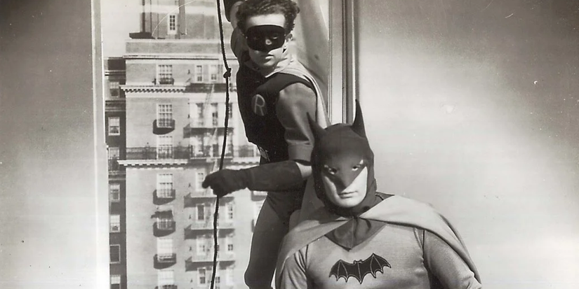 Batman and Robin stands near a window