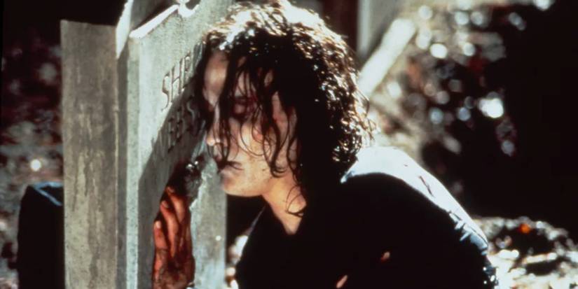 Eric Drave pressing the side of his face to a tomb in The Crow