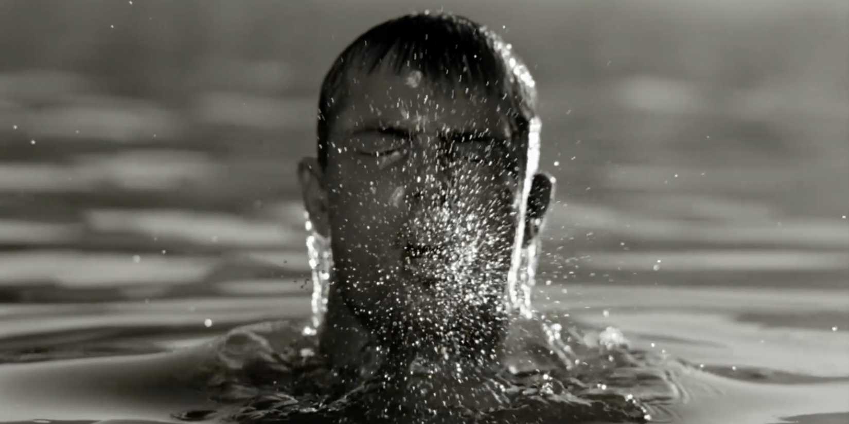 A man emerging from water in black and white in The Fall
