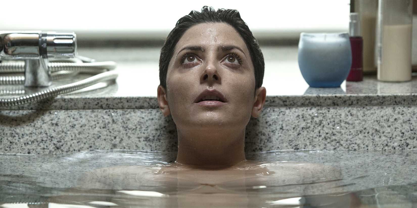 Bárbara Lennie staring up in a bathtub in The Invisible Guest