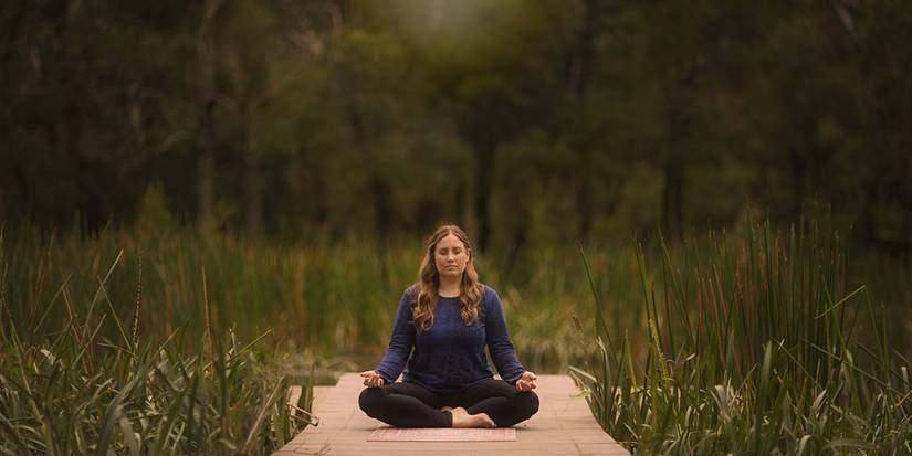 A woman meditating while doing yoga in Twisted Yoga.