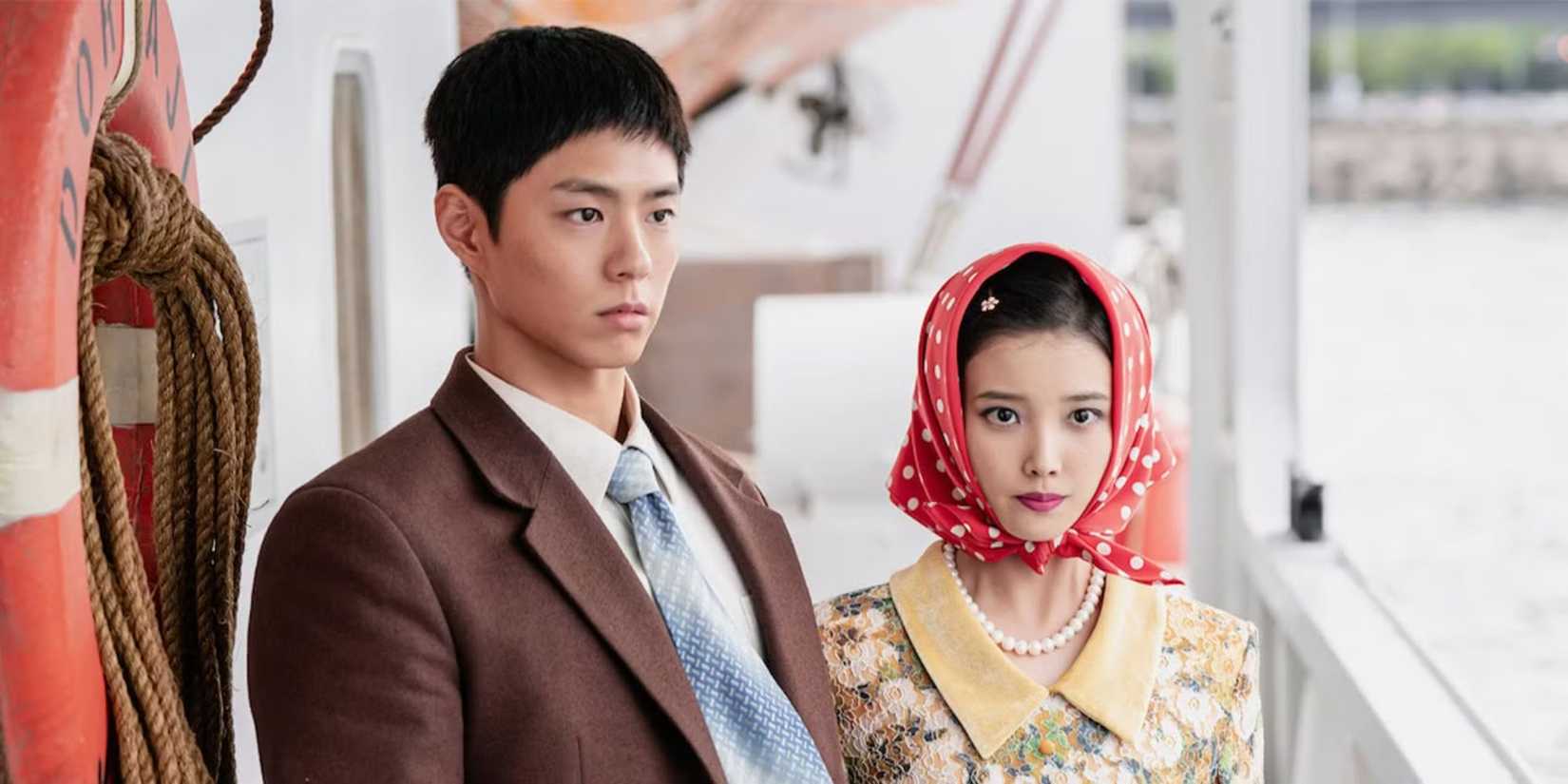 A young man stands next to a young woman wearing a headscarf on a boat in When Life Gives You Tangerines.