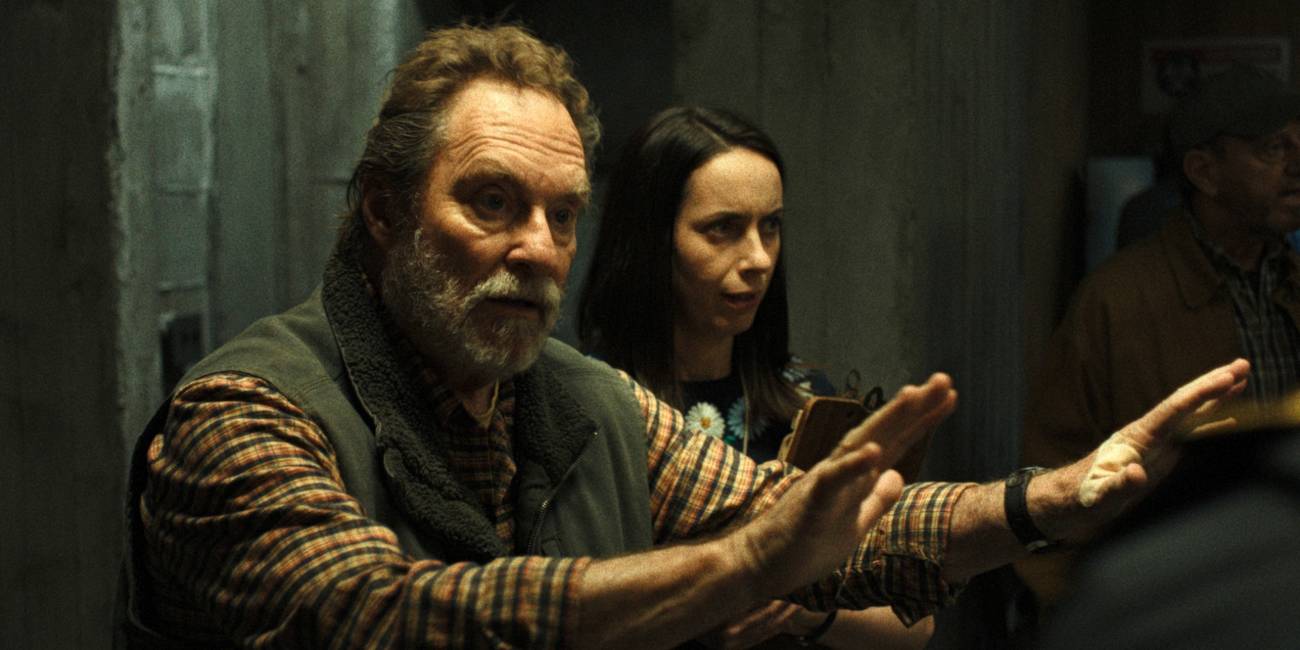 Stephen Root as Wyck standing in front of Kate O'Flynn as Patricia holding his arms out in Widow's Bay